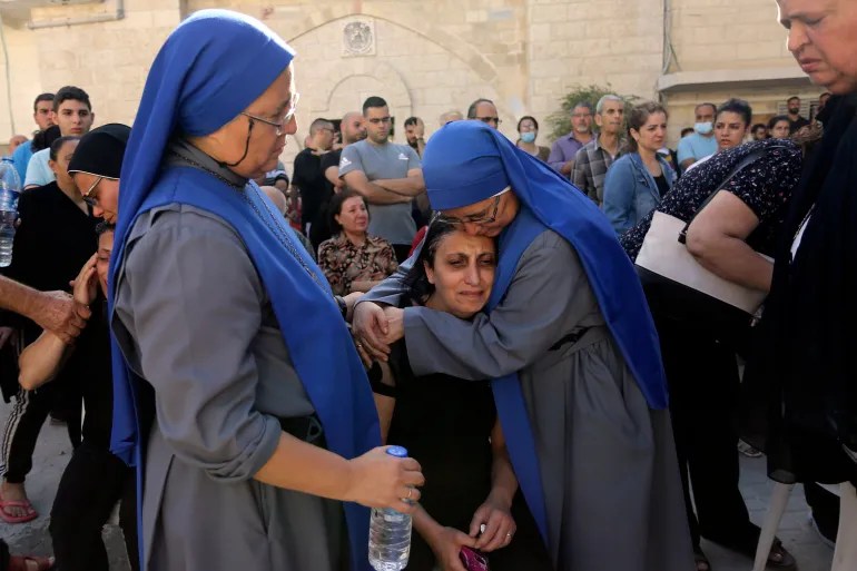 Nuns comfort a Palestinian woman during a funeral service on October 20, 2023, as she mourns the death of a relative killed in Israeli air strikes that hit a building attached to Gaza City’s Saint Porphyrius Church [Abed Khaled/AP]